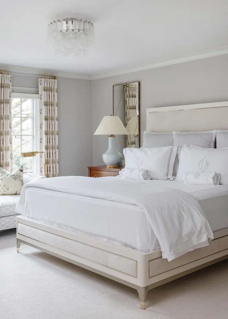 A custom Caracole bed is flanked by nightstands by Modern History. The ceiling fixture is from Visual Comfort.