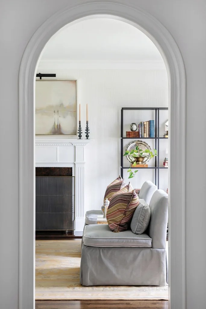 The painting over the fireplace is by local artist Margot Whitley. Striped tone-on-tone wallpaper adds subtle interest.