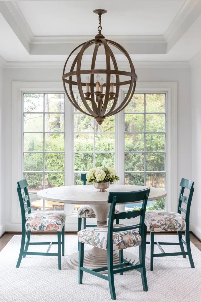 In the breakfast room, antique chairs were recovered and painted a deep teal green by Renew Charlotte. The chandelier had been in the dining room but worked well in the space, which has taller ceilings. An easy-to-clean indoor-outdoor rug was a practical choice for the busy area.