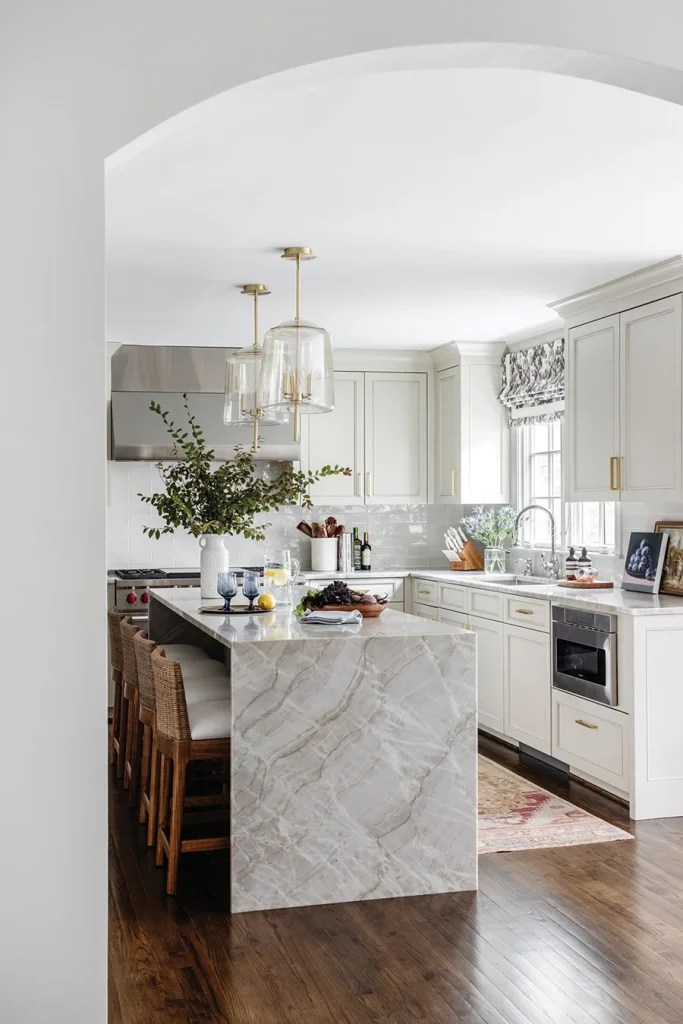 “In the kitchen, it was all about making the most of the space we had,” the homeowner says. The window over the sink was enlarged and a coffee bar was added. The island, finished with a waterfall edge, was extended to comfortably seat four.
